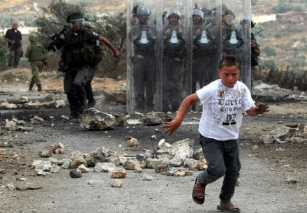 A young Palestinian protester runs away