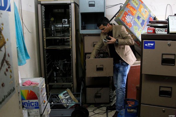 journalist-inspects-damage-to-Al-Khalil-radio-after-Israeli-raid-November-21-2015
